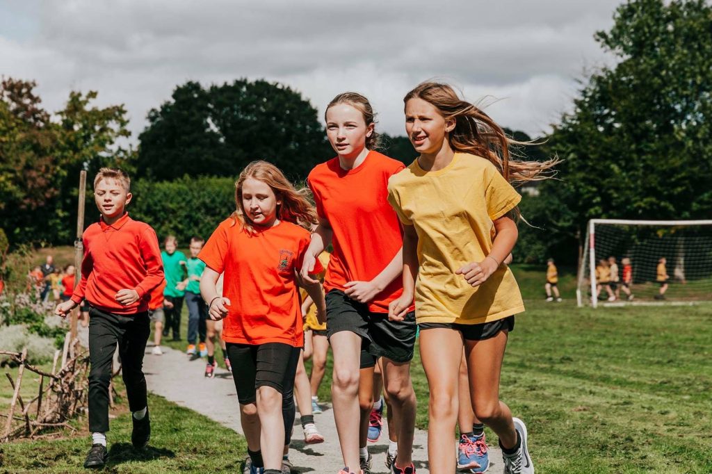 Children running on a sports pitch at a previous Monmouthshire Games event