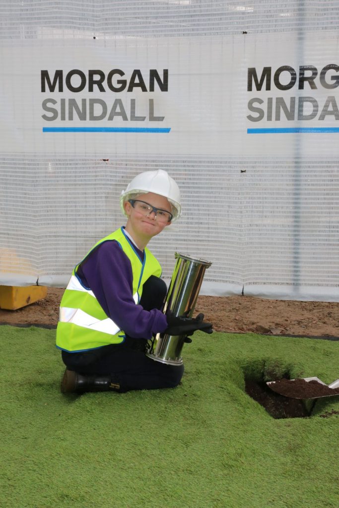 Deri View pupil with the time capsule at the site of the new King Henry VIII 3-19 school