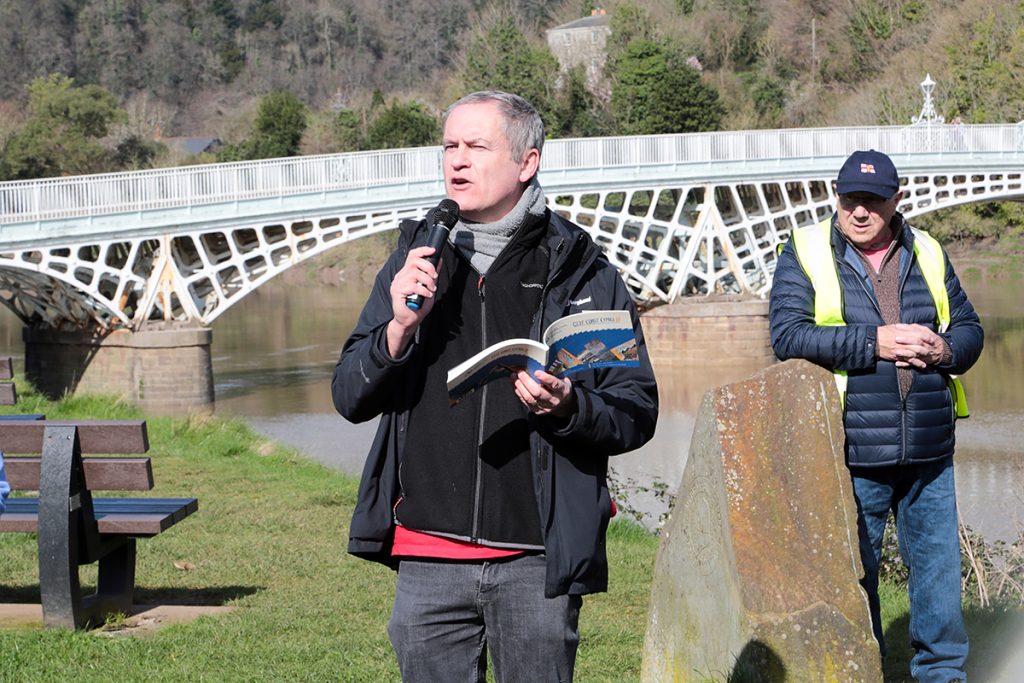 Former National Poet Ifor ap Glyn reads out his poem about the coast path, stood by the riverside in Chepstow