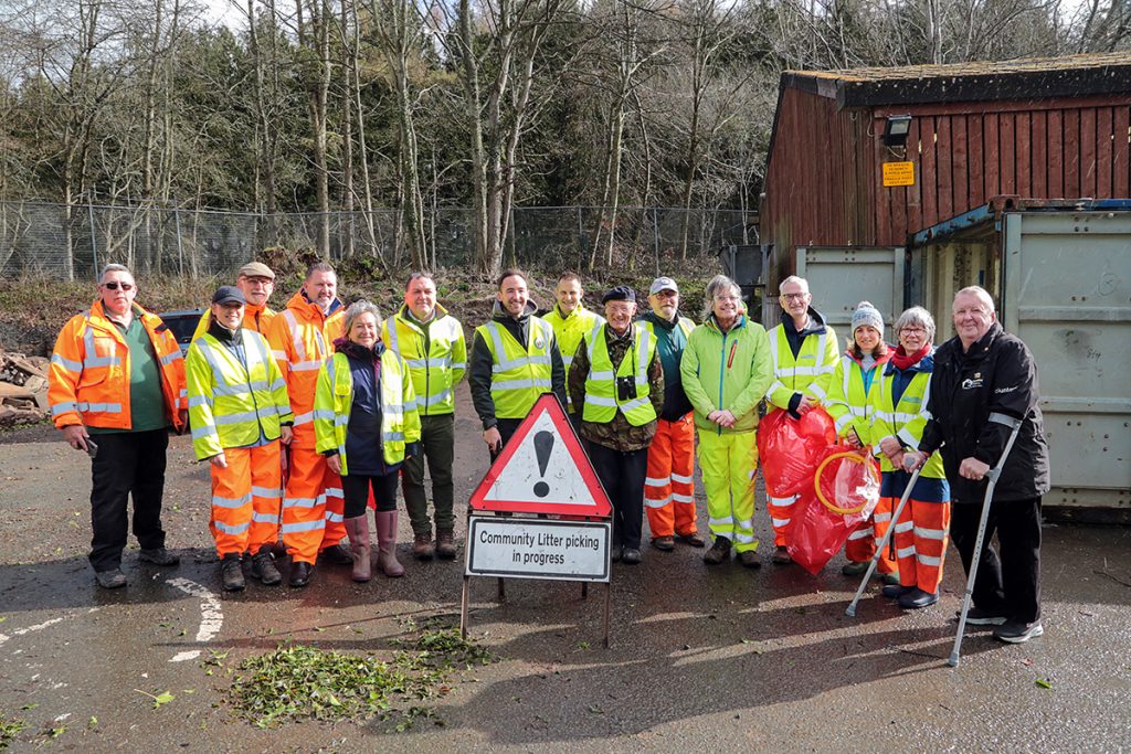 Litter-picking volunteers and officers in high vis vests from Monmouthshire County Council and Powys County Council join forces to tackle littering at Llangattock