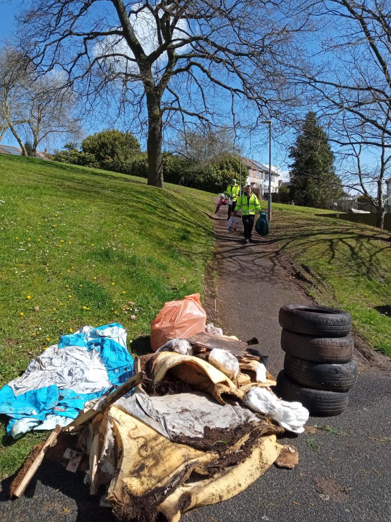 people picking up litter, with piles of litter in the foreground