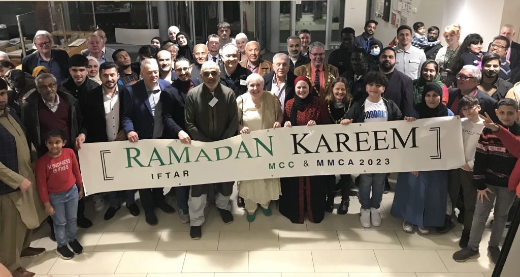 Everyone at the Iftar gathered with a banner