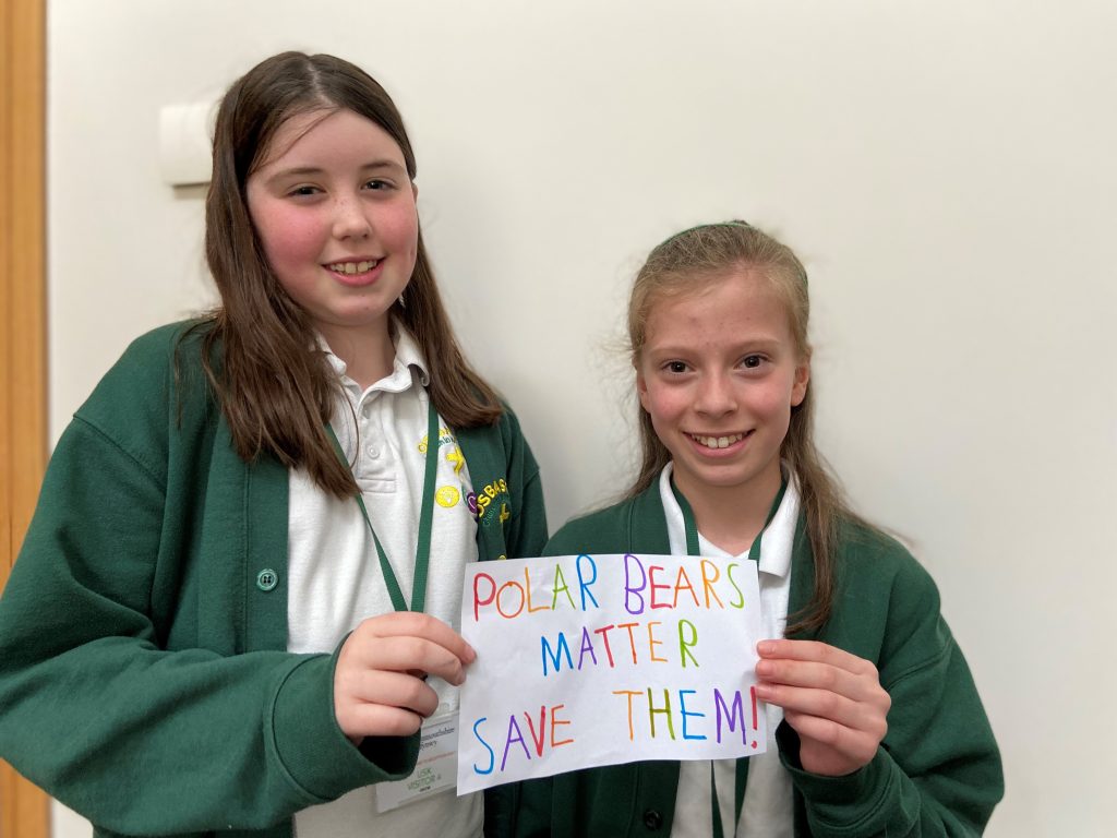 Two Osbaston pupils holding a sign that says 'Polar Bearsa matre, save them!