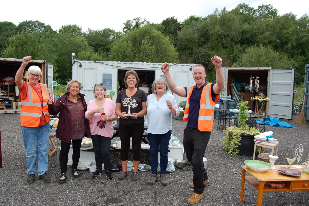 Llun o'r chwith i'r dde: Arwyr Cymunedol yn y Siop Ailddefnyddio, Ellen Quayle, Cherie Hogan, Laura Wilkinson, Candy Fuller a Christopher Williams gyda'r Cynghorydd Catrin Maby (ail o'r chwith)