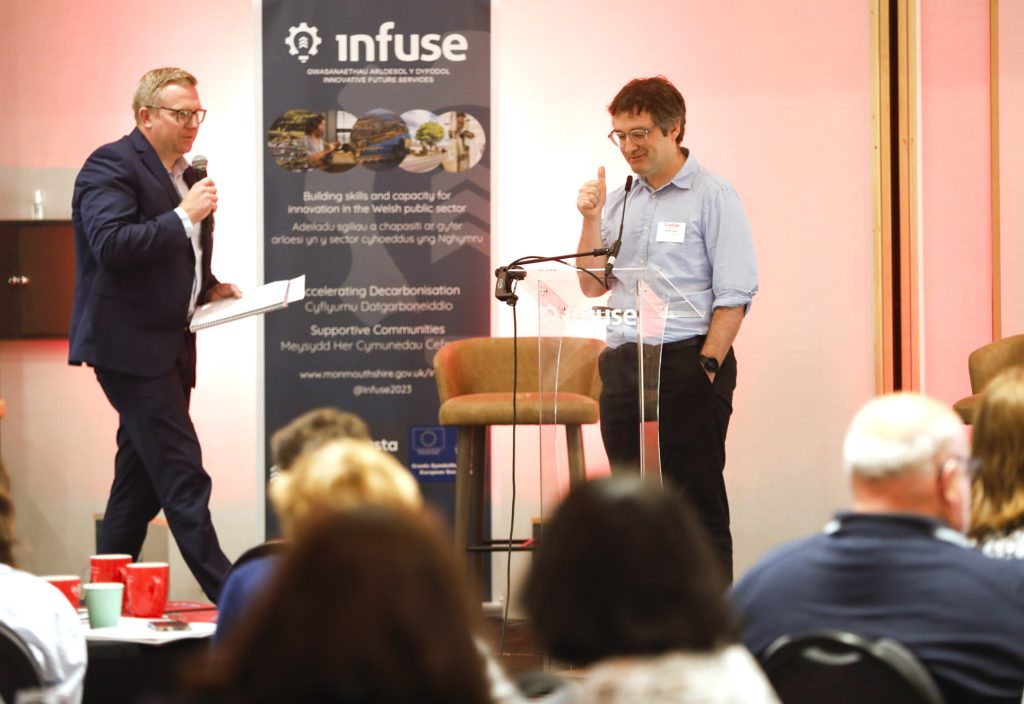 man gives thumbs up at conference