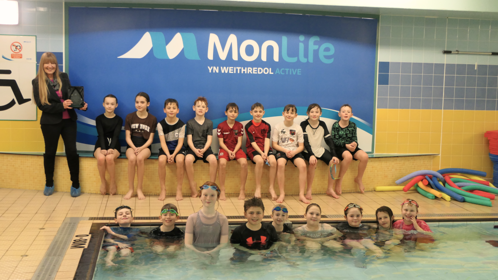 Cabinet Member for Equalities and Engagement, Cllr Angela Sandles with students from Magor Church in Wales Primary School at their school swimming lesson.
